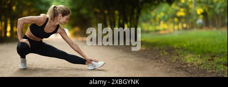 Donna attiva bionda di mezza età che si allunga nel parco pubblico Foto Stock