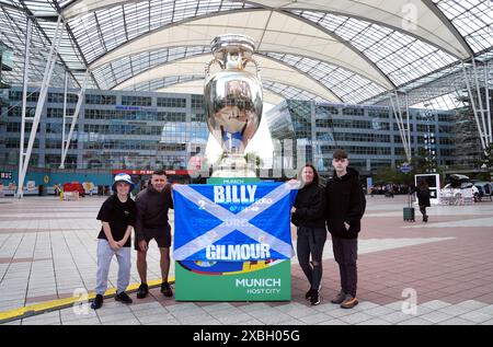 Tifosi scozzesi accanto al trofeo gigante fuori dall'aeroporto di Monaco. La Germania affronterà la Scozia nella prima gara di Euro 2024 di venerdì. Data foto: Mercoledì 12 giugno 2024. Foto Stock