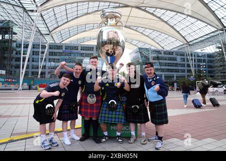 Tifosi scozzesi accanto al trofeo gigante fuori dall'aeroporto di Monaco. La Germania affronterà la Scozia nella prima gara di Euro 2024 di venerdì. Data foto: Mercoledì 12 giugno 2024. Foto Stock