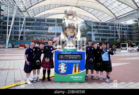 Tifosi scozzesi accanto al trofeo gigante fuori dall'aeroporto di Monaco. La Germania affronterà la Scozia nella prima gara di Euro 2024 di venerdì. Data foto: Mercoledì 12 giugno 2024. Foto Stock