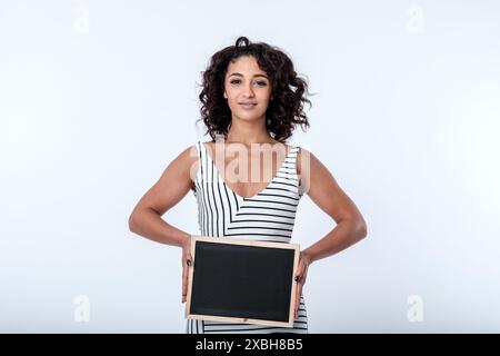 Una giovane donna d'affari, fiduciosa e accogliente, sorridente, ha un cartello con la lavagna con spazio per lo slogan pubblicitario o la messaggistica di concetto chiave. Copia spazio Foto Stock