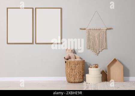 Camera per bambini con immagini vuote su una parete grigia. Design degli interni Foto Stock