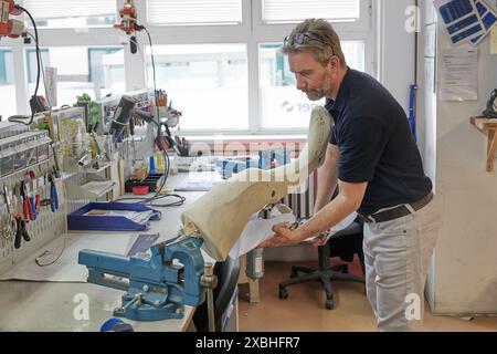 12 giugno 2024, Berlino: Una gamba protesica viene assemblata nel progetto "Prosthesis Center Berlin-Kyiv". Il numero di amputati in Ucraina è stimato tra 30.000 e 50.000. Allo stesso tempo, ci sono troppo pochi tecnici ortopedici in Ucraina per fornire a tutte le vittime di guerra cure rapide e buone. Janine von Wolfersdorff della ONG berlinese "Life Bridge Ukraine" ha pertanto avviato questo progetto per consentire l'istituzione e il funzionamento di un laboratorio comune di protesi a Kiev. Il Senato di Berlino sostiene il progetto come parte della partnership con Kiev. Foto: Joerg Carstensen/dpa Foto Stock