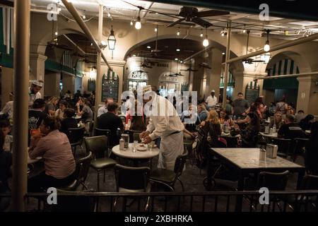 Una notte vivace al Cafe Du Monde, uno storico punto di riferimento di New Orleans conosciuto per i suoi bignè e caffè, nell'iconico quartiere francese. Foto Stock