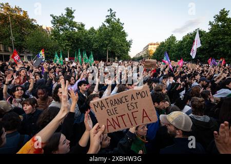 Un manifestante ha un cartello con scritto "la mia Francia è Antifa" tra la folla durante la manifestazione. In seguito alla vittoria di Jordan Bardella del partito nazionale di raggruppamento alle elezioni europee del 9 giugno e alla controversa decisione del presidente francese Emmanuel Macron di sciogliere l'Assemblea nazionale, migliaia di persone si sono riunite per il terzo giorno consecutivo a Place République in una massiccia manifestazione contro l'estrema destra e in favore della coalizione Front Populaire, creata dai partiti di sinistra la France Insoumise, dai socialisti, dai comunisti e dagli ecologisti. Foto Stock