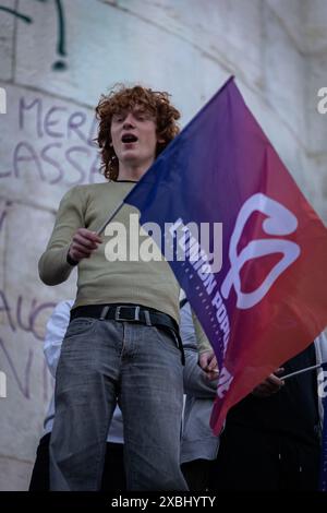 Un manifestante detiene una bandiera di la France Insoumise durante la manifestazione. In seguito alla vittoria di Jordan Bardella del partito nazionale di raggruppamento alle elezioni europee del 9 giugno e alla controversa decisione del presidente francese Emmanuel Macron di sciogliere l'Assemblea nazionale, migliaia di persone si sono riunite per il terzo giorno consecutivo a Place République in una massiccia manifestazione contro l'estrema destra e in favore della coalizione Front Populaire, creata dai partiti di sinistra la France Insoumise, dai socialisti, dai comunisti e dagli ecologisti. (Foto di Telmo Pinto/SOPA Images/Sipa USA) Foto Stock