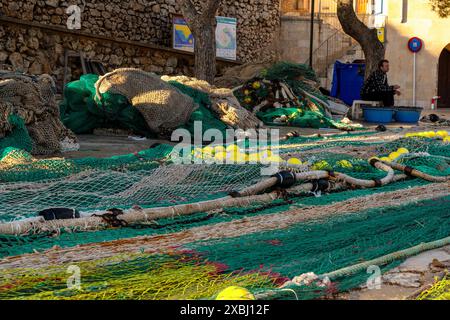 Puerto de Cala Figuera, Spagna - 22 gennaio 2024: Pescatore di Maiorca che ripara le reti e ripara le lenze di pesca nel porto di Cala Figuera a Mallor Foto Stock