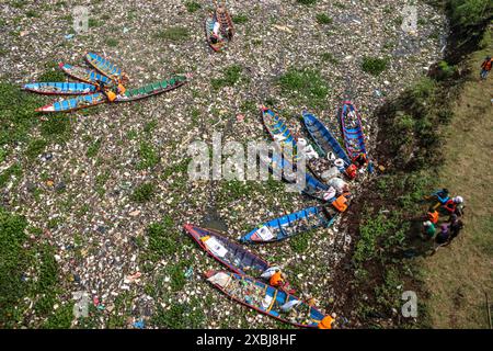 West Bandung Regency, Indonesia. 12 giugno 2024. Foto aerea degli ufficiali che puliscono mucchi di rifiuti nel fiume Citarum Batujajar, West Bandung Regency, West Java, Indonesia, il 12 giugno, 2024. si stima che il mucchio di rifiuti nel fiume Citarum, nell'area del distretto di Batujajar, sia lungo 3 chilometri e largo 60 metri, con un volume stimato di rifiuti di plastica superiore a 100 tonnellate. (Foto di Rasyad Yahdiyan/INA Photo Agency/Sipa USA) credito: SIPA USA/Alamy Live News Foto Stock