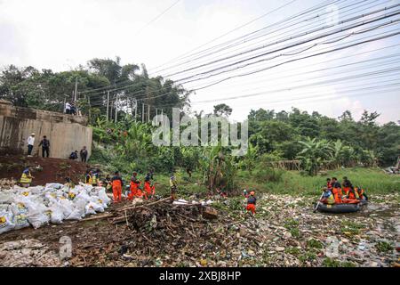 West Bandung Regency, Indonesia. 12 giugno 2024. Gli agenti che ripuliscono la spazzatura accumulata nel fiume Citarum Batujajar, West Bandung Regency, West Java, Indonesia, il 12 giugno, 2024. si stima che il mucchio di rifiuti nel fiume Citarum, nell'area del distretto di Batujajar, sia lungo 3 chilometri e largo 60 metri, con un volume stimato di rifiuti di plastica superiore a 100 tonnellate. (Foto di Rasyad Yahdiyan/INA Photo Agency/Sipa USA) credito: SIPA USA/Alamy Live News Foto Stock