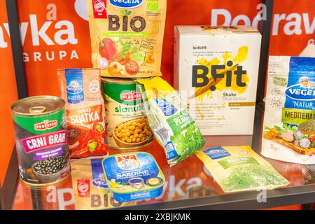 Osijek Croazia - 7 06 2024: Scaffale in un negozio di alimentari, che presenta una varietà di conserve e prodotti alimentari confezionati. Lo scaffale è pieno di prodotti Foto Stock