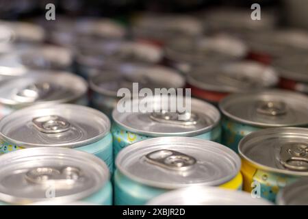 Lattine di birra colorate in metallo impilate su uno scaffale Foto Stock