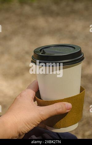 Giovane donna che tiene a mano un bicchiere di carta usa e getta . Foto di alta qualità Foto Stock