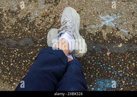 relax femminile con pantaloni blu e scarpe grigie con gamba trasversale. Foto di alta qualità Foto Stock