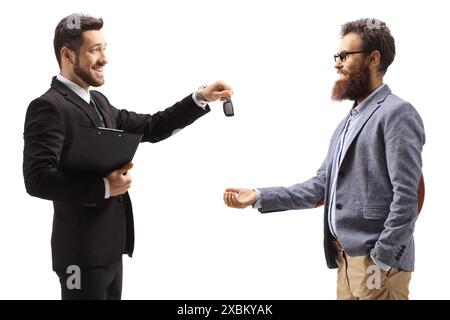 Uomo d'affari che dà le chiavi di una macchina a un uomo sorridente barbuto isolato su sfondo bianco Foto Stock