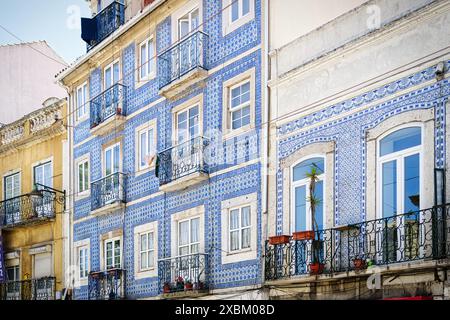 tipico edificio residenziale di lisbona con la facciata piastrellata e i balconi con le ringhiere ornate in ferro battuto Foto Stock