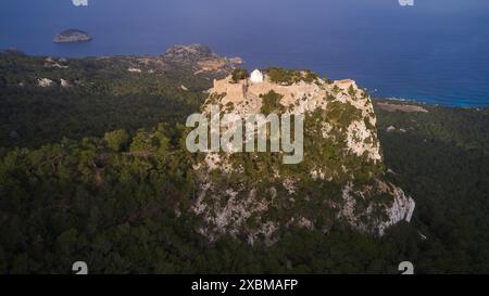 Vista aerea di un castello su una collina boscosa al crepuscolo, Kastro Monolithou, castello Monolithos, castello di roccia, villaggio Monolithos, Rodi, Dodecaneso, greco Foto Stock