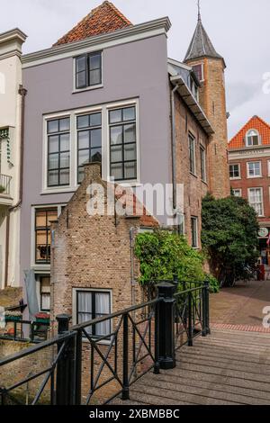 Case lungo un ponte con facciate in mattoni, grandi finestre e piante verdi in una strada tranquilla, Dordrecht, olanda, paesi bassi Foto Stock