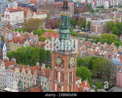 Una grande torre dell'orologio sovrasta una città con molti edifici storici e alberi verdi, il tutto da una vista a volo d'uccello, Danzica, Polonia Foto Stock