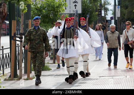 Evzones in abito tradizionale marciano al cambio della guardia di fronte all'edificio del parlamento, Piazza Syntagma, Atene, Grecia Foto Stock