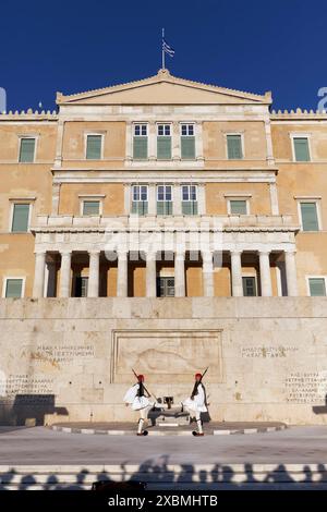 Due Evzone in abito tradizionale di fronte all'edificio del parlamento, Tomba del Milite Ignoto, Piazza Syntagma, Atene, Grecia Foto Stock