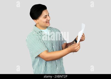 Giovane lavoratore in ufficio in abito casual con white paper che dà gesti ed esecutori felici eccitati Foto Stock