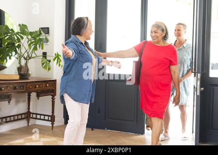 Gruppo eterogeneo di donne anziane che si salutano a braccia aperte e sorrisi Foto Stock
