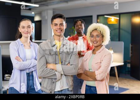 Colleghi diversi stanno in piedi con fiducia e le braccia incrociate, a dimostrazione dell'unità aziendale Foto Stock