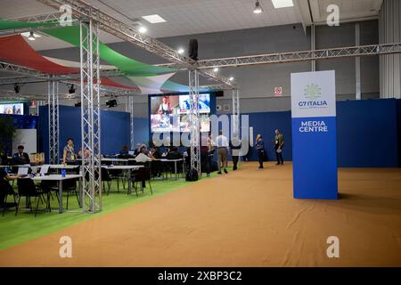 Bari, regione Puglia, Italia. 12 giugno 2024. L'interno della fiera Levante di Bari, allestito come centro stampa con postazioni attrezzate per giornalisti e operatori video in occasione del summit G7. Giornalisti e fotogiornalisti in attesa davanti agli schermi che indicano gli aggiornamenti del vertice. (Credit Image: © Marco Cordone/ZUMA Press Wire) SOLO PER USO EDITORIALE! Non per USO commerciale! Foto Stock