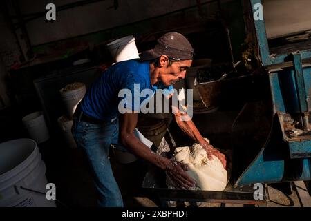 Un operaio messicano prepara l'impasto fresco dal mais per fare tortillas in un tortillería a Morelia, Michoacán, Messico. Foto Stock