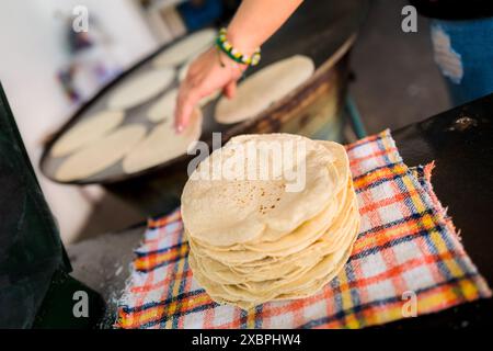 Una pila di tortillas appena fatte è stata posta su un panno in un tortillería a Morelia, Michoacán, Messico. Foto Stock