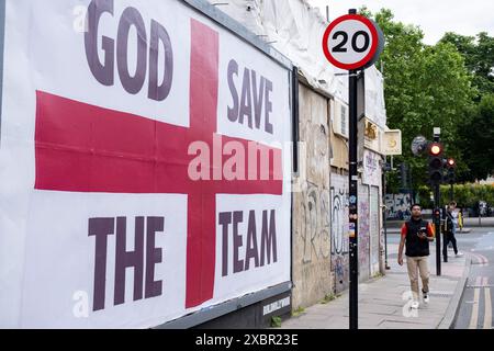 God Save the Team, bandiera St Georges su larga scala a sostegno della squadra di calcio inglese prima di prendere parte agli Euros del Campionato europeo di calcio UEFA il 12 giugno 2024 a East London, Regno Unito. Il poster del cartellone Foto Stock