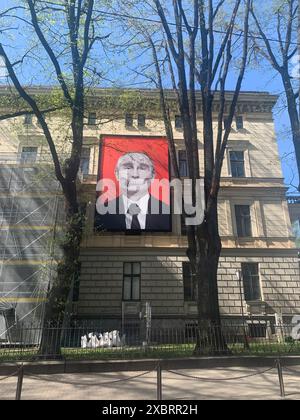 Riga, Lettonia, 2 maggio 2024: Poster di grande formato sulla facciata di Vladimir Putin, volto che sembra un teschio. Appeso proprio di fronte all'ambasciata russa Foto Stock