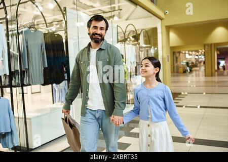 Un uomo e sua figlia si godono una piacevole passeggiata attraverso un vivace centro commerciale durante un fine settimana. Foto Stock