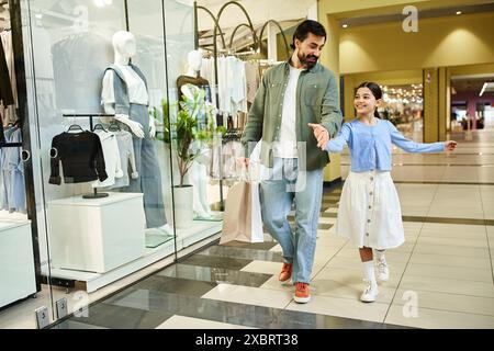 Un padre e sua figlia camminano insieme in un vivace centro commerciale, godendosi una piacevole gita nel fine settimana. Foto Stock