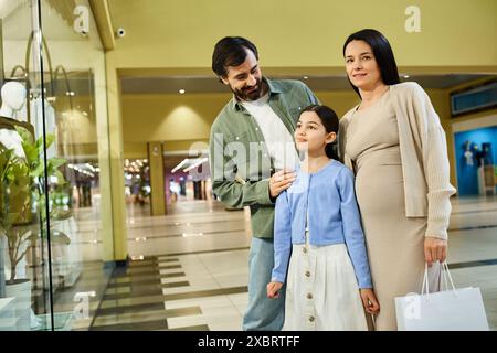 Fate felici la famiglia con le borse dello shopping, godendovi una piacevole passeggiata in un vivace centro commerciale. Foto Stock