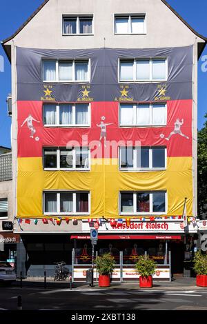 Con una grande casa coperta di bandiera tedesca in occasione del Campionato europeo di calcio UEFA 2024, Trierer Street, Colonia, Germania. grosser mit D Foto Stock