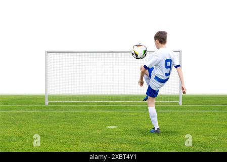 Giocatore di calcio che giocherà una palla su un campo con un gol sullo sfondo. Perfetto per contenuti sportivi, di allenamento, giovanili e fitness. Ideale per attività fisica Foto Stock