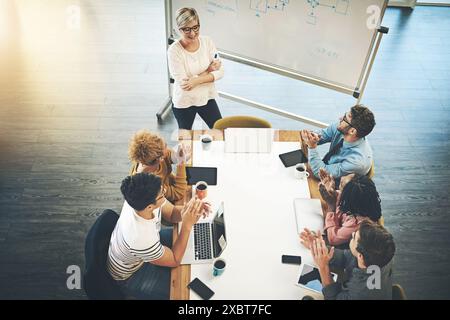 Uomini d'affari, presentazioni e coaching con applausi durante un incontro di ringraziamento, congratulazioni o complimenti in ufficio. Vista dall'alto, gruppo o. Foto Stock