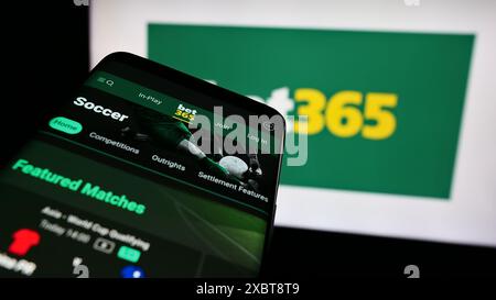 Telefono cellulare con sito web della società britannica di scommesse sportive Bet365 davanti al logo aziendale. Mettere a fuoco in alto a sinistra sul display del telefono. Foto Stock