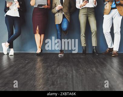 Business, persone e parete dell'ufficio con gambe, colloquio di lavoro e selezione del personale per la carriera dei dipendenti in azienda. Sala d'attesa, coda e candidato Foto Stock