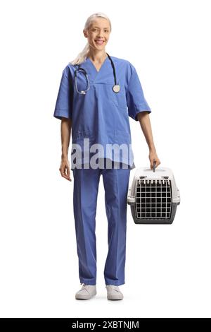 Veterinario femminile in uniforme blu che tiene un trasportino per animali da compagnia isolato su sfondo bianco Foto Stock