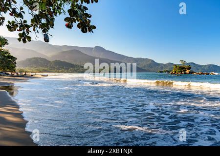 La remota spiaggia di Castelhanos sull'isola di Ilhabela con montagne e foreste intorno Foto Stock