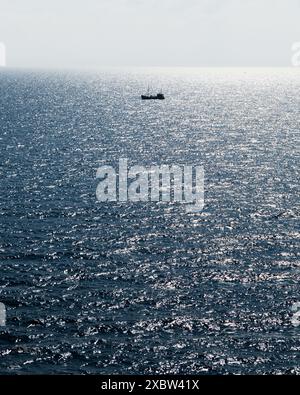 L'oceano Atlantico senza fine con un piccolo peschereccio solitario in un clima calmo e soleggiato. Fotografia di paesaggi Foto Stock