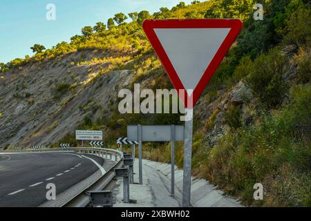 Segnali di priorità, il segno di resa è un triangolo equilatero bianco con un bordo rosso, N-420, Fuencaliente, Provincia di Ciudad Real, Spagna Foto Stock