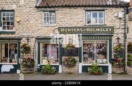 I cacciatori di specialità gastronomiche di Helmsley all'esterno con cesti di fiori appesi e lavori di pittura esterni in corso. Helmsley, North Yorkshire, Inghilterra, Regno Unito. Foto Stock