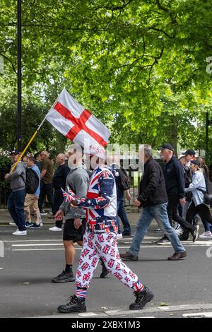 Londra, Regno Unito. 1 giugno 2024. I sostenitori di Tommy Robinson, ex leader della Lega di difesa inglese di estrema destra, marciano tenendo bandiere durante una manifestazione di protesta contro quello che considera un sistema di polizia a due livelli. Il documentario Lawfare di Tommy Robinson fu mostrato durante il rally che seguì la marcia. Crediti: Mark Kerrison/Alamy Live News Foto Stock