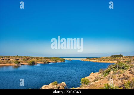 La foce di Yardie Creek nel Cape Range National Park, Australia Occidentale. Rocce con vegetazione dell'entroterra, in lontananza l'Oceano Indiano Foto Stock