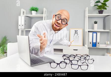 Ritratto di un oftalmologo maschile felice e divertente seduto in ufficio a controllare la visione di un paziente Foto Stock