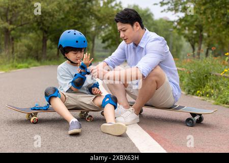 Boy skateboard con papa' Foto Stock