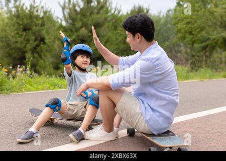 Boy skateboard con papa' Foto Stock